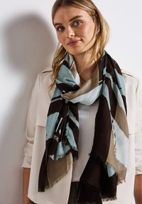 Halstørklæde med en blanding af turkis, brun og beige farver i et abstrakt mønster. Fremstillet af blødt stof med frynset kanter.