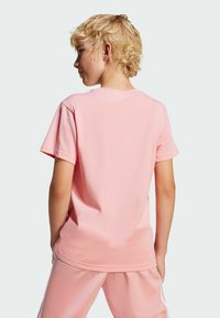 Pink cotton t-shirt with a crew neck and short sleeves, viewed from the back, featuring a relaxed fit and soft texture.