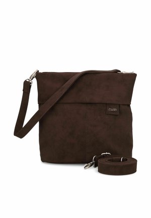 Bolso bandolera de ante marrón oscuro con cremallera superior, correa ajustable y una correa adicional desmontable enrollada junto a él.