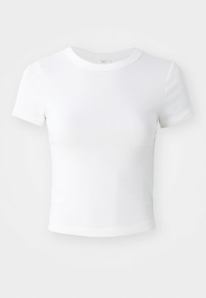 T-shirt courte à manches courtes, blanche, avec un col rond, présentée sur un fond neutre et lumineux.