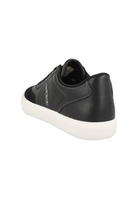 Baskets noires avec une tige en cuir, des accents en suède, une semelle en caoutchouc blanche et des lacets plats. Détails de coutures remarquables le long des côtés.