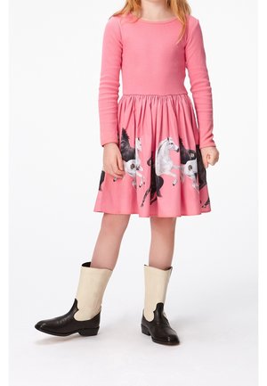 Vestito rosa a maniche lunghe con gonna arricciata, caratterizzato da una stampa di cavalli. Abbinato a stivali da cowboy neri e crema, che evidenziano un design giocoso.