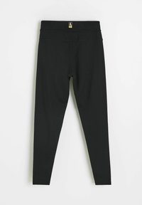 Czarne legginsy wykonane z elastycznego materiału; posiadają wysoki pas i gładką fakturę z minimalną liczbą szwów dla smukłego wyglądu.