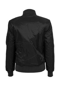Veste bomber noire en tissu lisse et brillant. Col et poignets côtelés, avec une ceinture ajustée. Présente un design minimaliste sans quincaillerie visible.