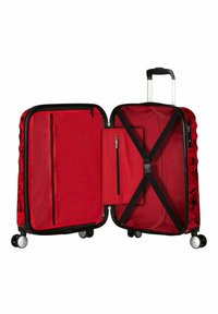 Valigia rigida rossa con un design floreale nero. Interno dotato di tasche in rete, un compartimento con zip e cinghie incrociate. Ruote a scorrimento fluido.