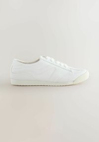 Hvide sneakers med et tekstureret design, der har en glat overdel, seks snørehuller og en kontrastfarvet gummisål med et zigzag-mønster.