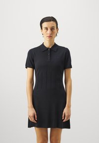 Námořnické polo šaty s krátkým rukávem, knoflíkovou légou a sklady v designu. Měkká texturovaná tkanina s mírným rozšířením na spodním lemu.