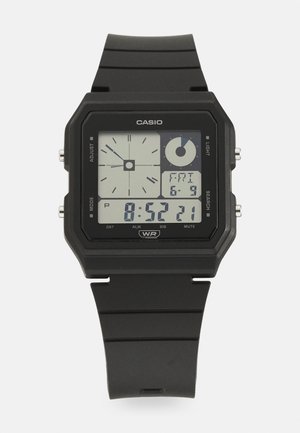 Czarny cyfrowy zegarek Casio z kwadratową tarczą, pokazujący czas 8:52:21, datę piątek 6-9 oraz analogowy wyświetlacz zegara.