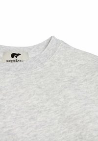 Lichtgrijze katoenen sweatshirt met een ronde halslijn en textuurstof, met een label met de tekst "slopes&tow" nabij de kraag.
