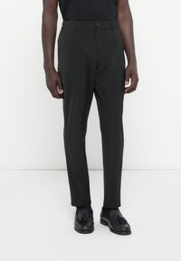 Svarta skräddarsydda byxor med rak bendesign, med knappstängning, sidofickor och ett mjukt, lätt tyg.