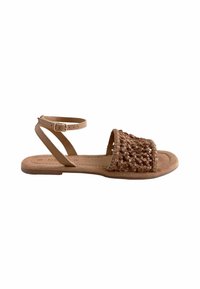 Tan lædersandal med vævet overdel, flad sål og justerbar ankelrem. Har teksturerede detaljer og åben tå-design.