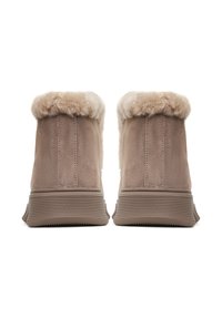 Két bézs velúr téli csizma bolyhos krém színű prémes béléssel és bordázott gumitalppal, hátulról, fehér háttér előtt bemutatva.