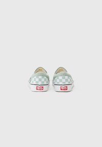 Green and white checkerboard slip-on sneakers with a cushioned interior, rubber sole, and red brand logo on the heel.
