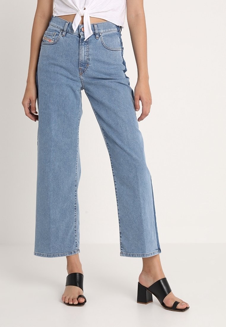 Ljust blå högmidjade jeans med vida ben, tillverkade av denim, med klassisk femficksdesign och knappgylf. Svarta öppna klackar med blockklack.