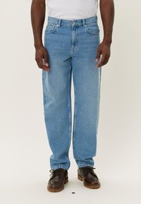 Light blue denim jeans with a relaxed fit, featuring a button and zip closure, five pockets, and minimal fading. Legs are straight-cut.