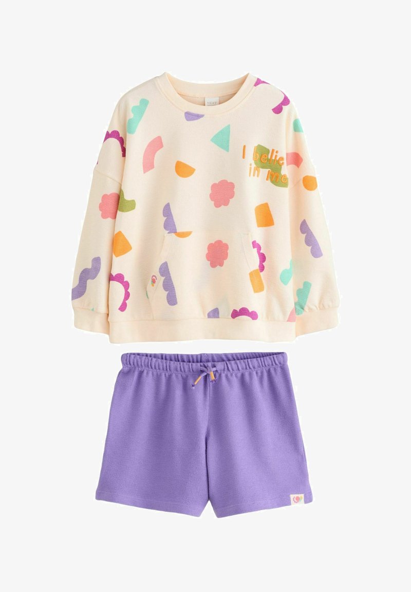 Cream sweatshirt with colorful shapes and "I believe in me" text, paired with purple elastic waist shorts.