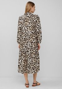Maxi-jurk met luipaardprint, lange pofmouwen, gelaagde zoom en lichtgewicht materiaal. Kleurenpalet in beige en bruin.