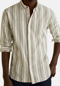 Camicia leggera con bottoni realizzata in misto lino. Presenta righe verticali beige e bianche, maniche lunghe e colletto a punte.