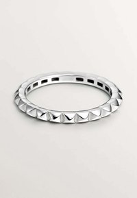 Brazalete de plata con un patrón alternado de superficies lisas y aristas en forma de pirámide, con un acabado pulido y un diseño abierto.