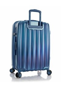 Harde koffer in tinten van blauw met een geribbelde oppervlakte, uitschuifbare handgreep en vier wielen voor mobiliteit. Gladde textuur en stevig ontwerp.