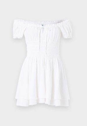 White off-the-shoulder dress with smocked bodice, short puff sleeves, and tiered ruffled hem. Made of lightweight, textured fabric.