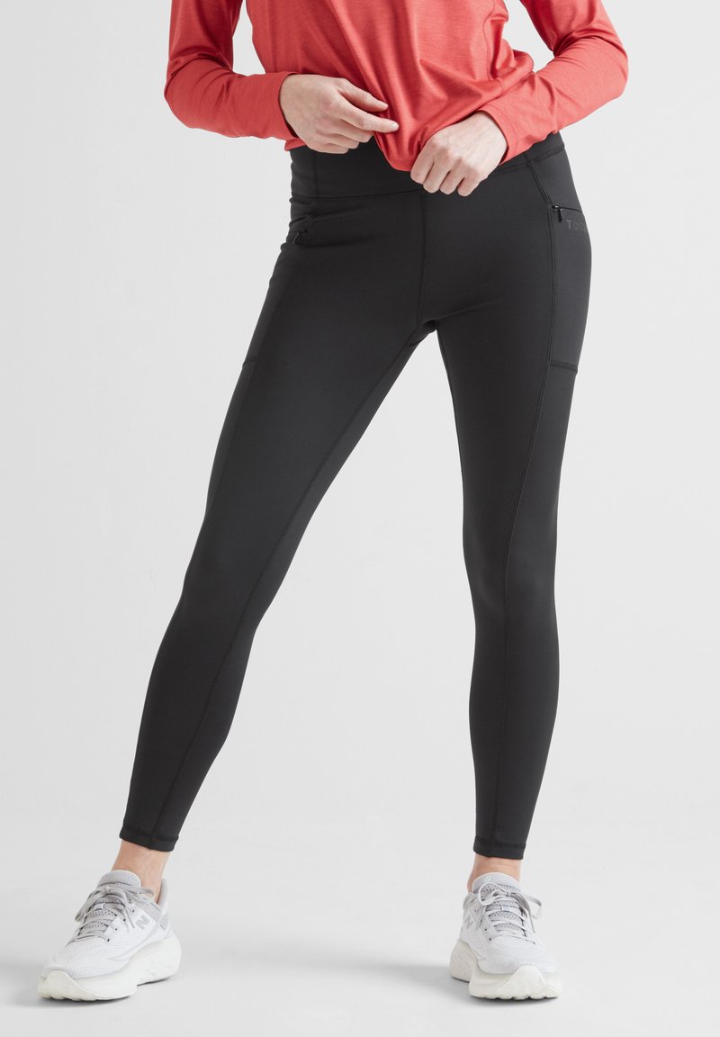 Black athletic leggings with a fitted design, featuring pockets on both sides, made from a stretchy material for comfort and movement.