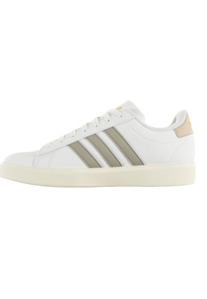 Baskets blanches avec trois rayures grises, tige en cuir texturé, semelle en caoutchouc arrondie et un accent beige au talon.
