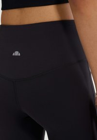 Hoge taille zwarte leggings van rekbare stof, met platte naden en een klein logoaccent op de tailleband.