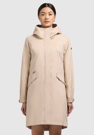 Beige regenjas met een capuchon en twee zijzakken, gemaakt van een gladde, waterafstotende stof en met een licht gebogen zoom.
