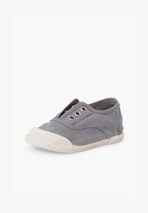 Szary sportowy but wsuwany wykonany z płótna z białą gumową podeszwą i czubkiem, posiadający trzy metalowe oczka na sznurowadła, bez sznurowadeł.