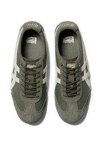 Green athletic shoes with a textured upper, suede and leather materials, white stripes on the sides, and an oval toe design.