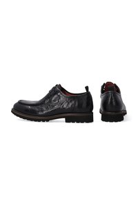 Zwarte leren schoenen met een glanzende afwerking, ronde neus, vetersluiting, gestructureerd bovenwerk en een robuuste rubberen zool. Inclusief een trekband aan de achterkant.
