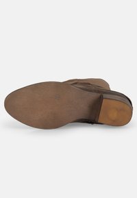 Suola di stivale in suede marrone con forma arrotondata, superficie texturizzata e tacco piatto. Presenta una suola in gomma resistente con un sottile motivo di battistrada.