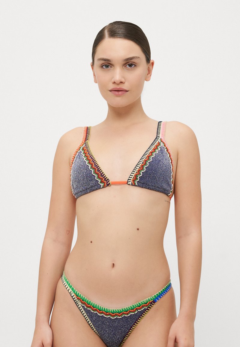 Top bikini triangolare in tessuto texturizzato, con cuciture e dettagli colorati, dotato di spalline regolabili. La parte inferiore abbinata presenta dettagli simili.