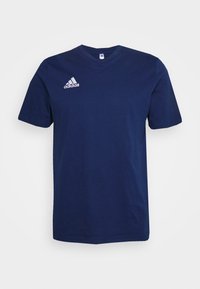 Námořnická modrá bavlněná trička s krátkými rukávy a kulatým výstřihem. Na levé straně hrudi je bílá logo Adidas. Jednoduchý, minimalistický design.