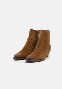 Ruske nubuk ankle boots med lav hæl, spidse tæer, lynlås i siden og bølgede designaccenter på overdelen. Teksturering.
