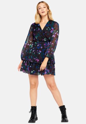 Black floral dress with long sleeves, layered ruffles, and a wrap design. Features vibrant purple and green patterns on a sheer fabric.