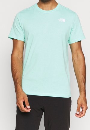 Krátké tričko světle zelené barvy s krátkými rukávy, vyrobené z měkké, lehké látky, s klasickým kulatým výstřihem a nenápadným logem na levé straně hrudníku.