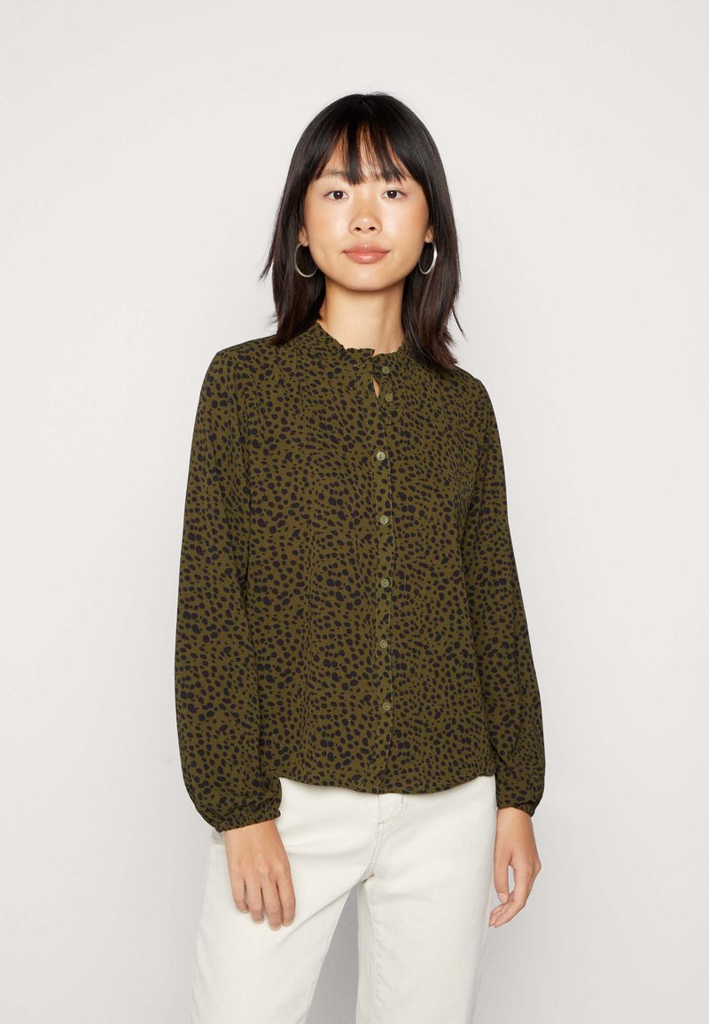 Blusa de manga longa, verde-oliva, com padrão de manchas pretas, apresentando um colarinho franzido e fecho de botões à frente, e punhos de mangas franzidos.