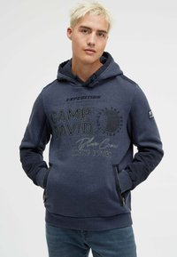 Navy blue hoodie with a front graphic print, featuring "Camp David" text. It has contrasting dark blue sleeves and zipped side pockets.