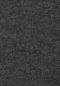 Gros plan de la texture d'un tissu tricoté côtelé gris foncé montrant des crêtes verticales et des fibres.