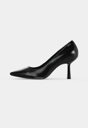 Un escarpin noir brillant à bout pointu et à talon haut et fin, présenté de profil sur un fond clair uni.