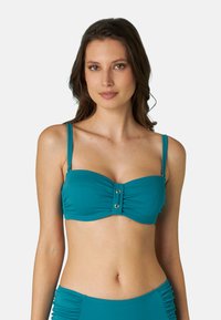 Top bikini color turchese con un design arricciato, presenta un dettaglio centrale a bottone e sottili spalline regolabili. Tessuto morbido e elasticizzato.