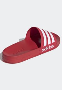 Röd halksandal med vit tre-stripes design, tillverkad av mjukt material, med en konturerad form och präglad "cloudfoam"-logotyp.