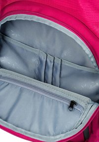 Interno dello zaino fucsia con fodera in tessuto grigio, dotato di tasche per riporre oggetti, una cerniera e un materiale testurizzato.