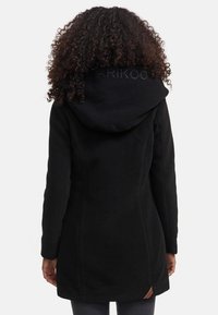 Black hooded coat featuring smooth fabric, tailored fit, and side pockets. Includes a leather logo accent near the hem.