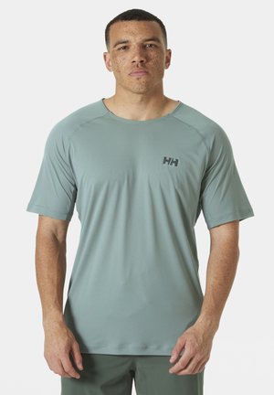 T-shirt de sport vert clair en tissu lisse et évacuant l'humidité. Il possède des manches courtes, un col rond et un petit logo sur la poitrine.