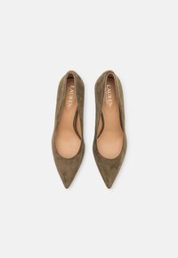 Olivgröna mockapumps med spetsiga tår, urtagna sidor och ljusbruna innersulor, med "LAUREN Ralph Lauren" präglat i guld.
