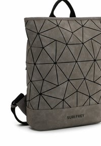 Mochila gris con un patrón de líneas geométricas negras, hecha de material suave, que cuenta con dos asas y correas ajustables para llevar.
