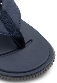 Marineblaue Flip-Flops mit einer strukturierten Gummisohle. Der Riemen besteht aus gewebtem Stoff mit einem Zickzackmuster und ist an der Basis befestigt.